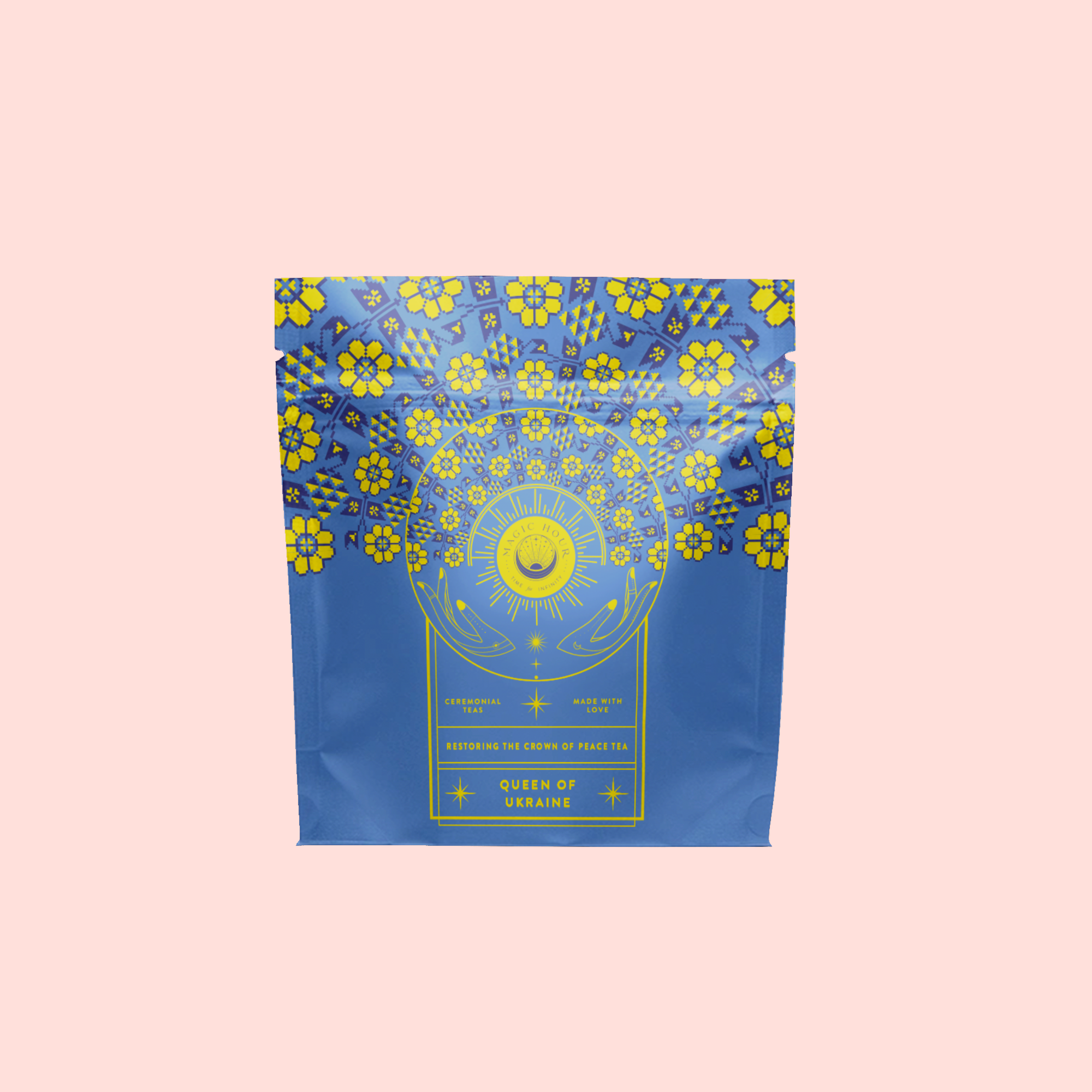 The Queen of Ukraine: Spring Blossom Tea comes in a blue and yellow package with floral patterns, a sun and moon motif, and highlights organic chamomile blossoms and butterfly pea flower on a light pink background.