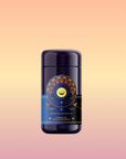 A dark blue tea canister labeled "Queen of the Rainforest : Cacao-Berry Tea" with celestial and botanical designs stands centered on a pink and yellow gradient background.