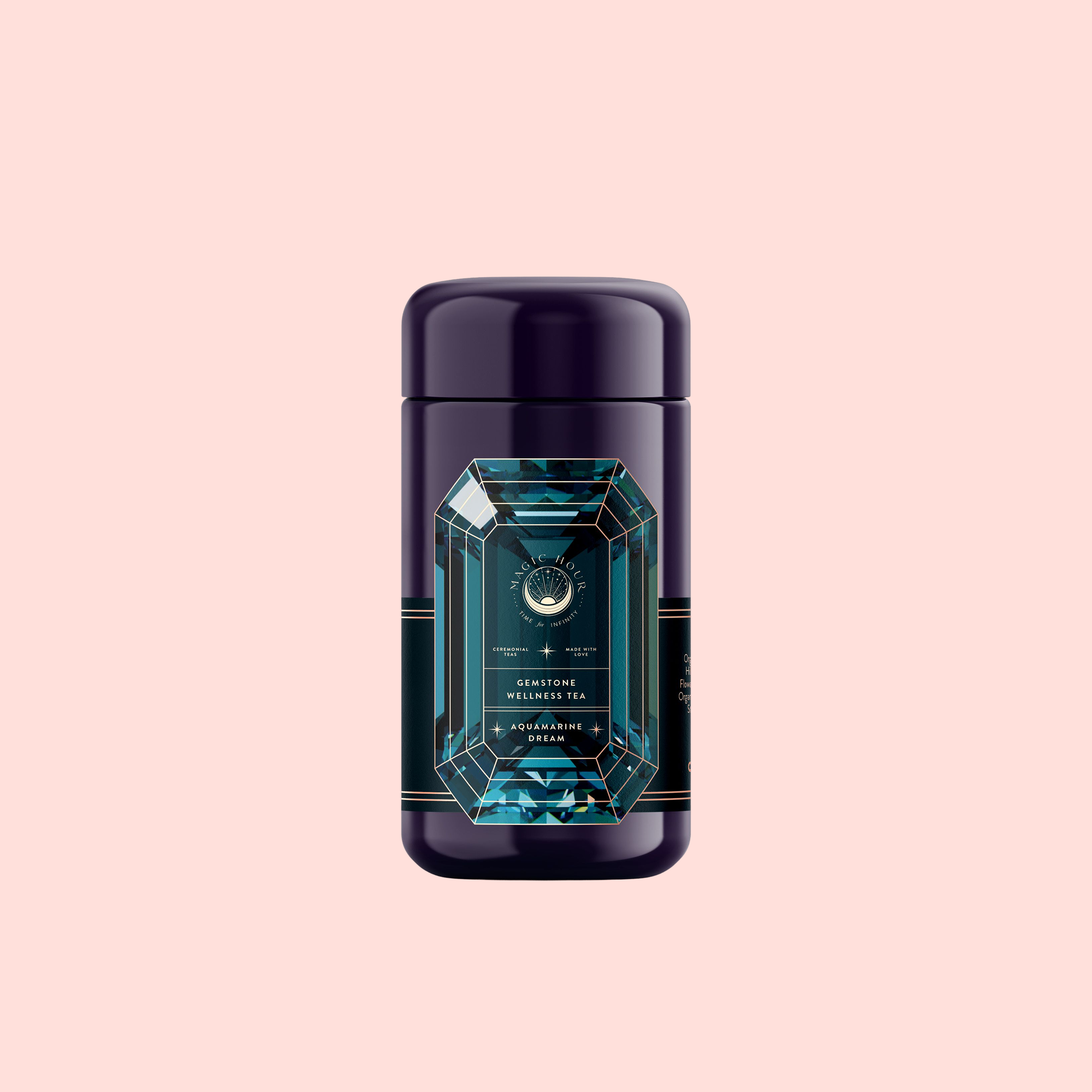 A dark purple cylindrical tea canister with a blue gemstone-shaped label displaying "Aquamarine Dream - Soothing Herbal Ayurvedic Adrenal Tonic" sits against a soft pink background.