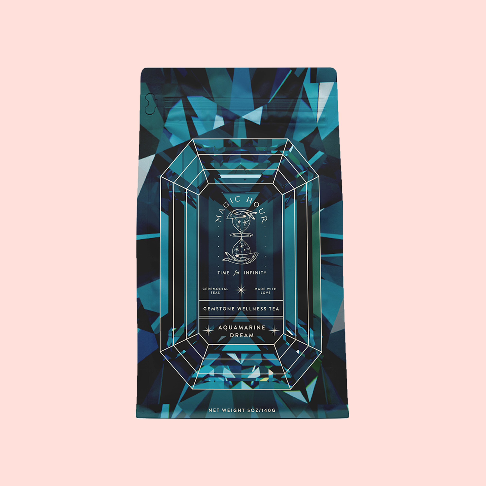 A blue and teal geometric tea package labeled "Aquamarine Dream - Soothing Herbal Ayurvedic Adrenal Tonic," a calming herbal tea with a gemstone illustration, is displayed against a light pink background.