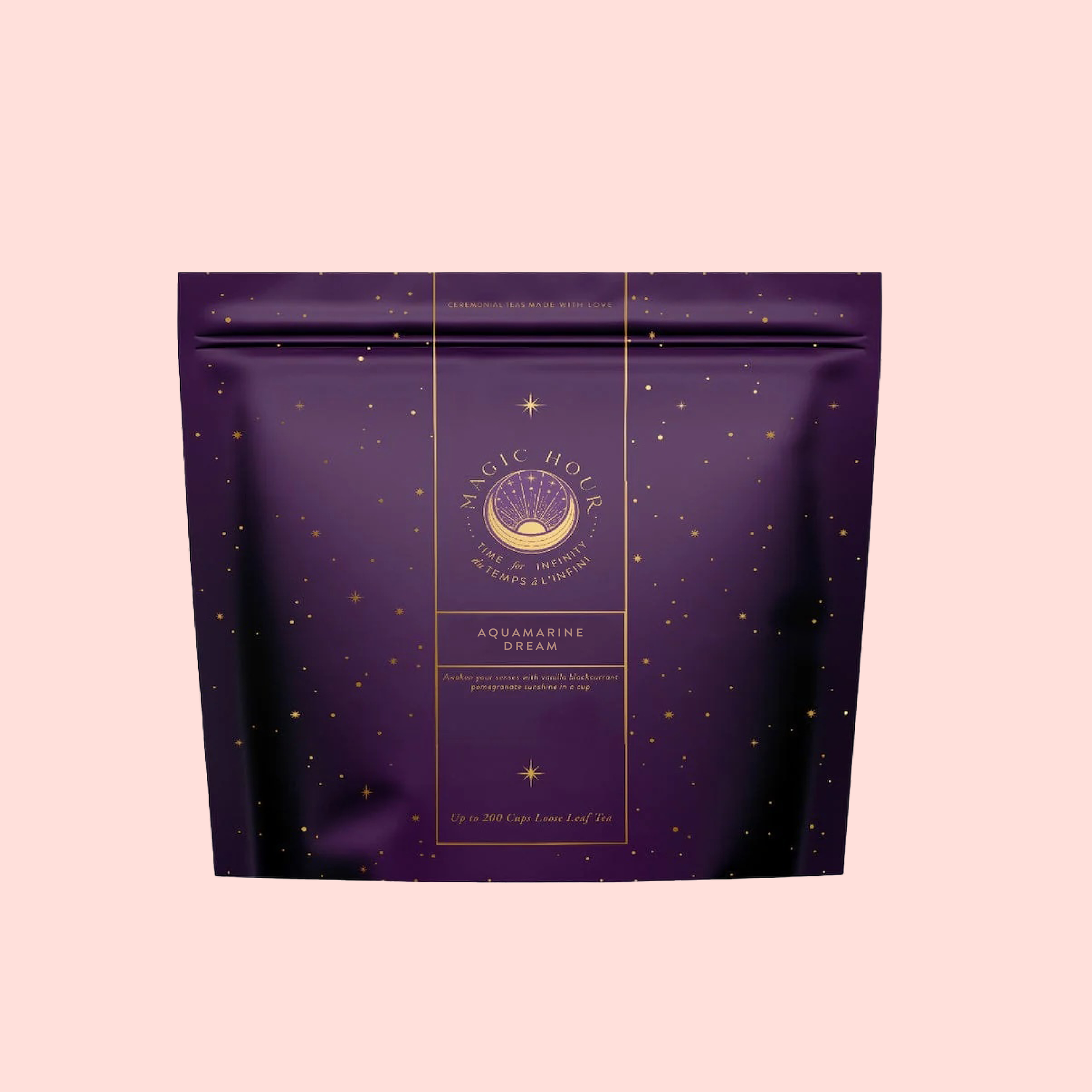 A purple resealable tea pouch labeled “Aquamarine Dream - Soothing Herbal Ayurvedic Adrenal Tonic,” adorned with gold star patterns, sits against a light pink background.