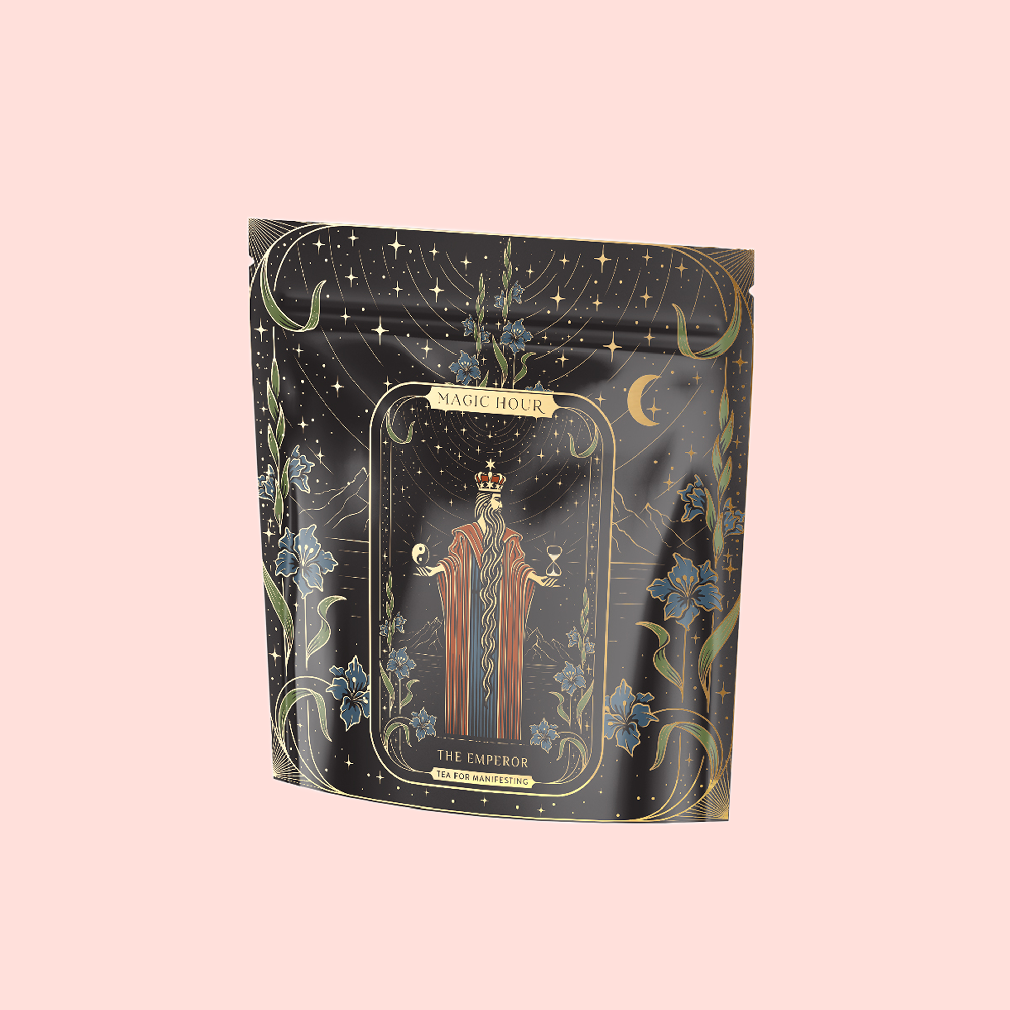 A decorative black and gold tea package labeled "Magic Hour," featuring "The Emperor" tarot card art with ornate floral and celestial designs on pale pink, showcases The Emperor: Green Chaga Chai with Lion's Mane and Reishi for immune support.