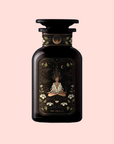 A dark glass bottle labeled "The Oracle: Lemon Lavender Tea for Supporting the Gut-Brain Axis" features an illustrated meditating figure amid celestial and botanical designs, set against a soft pale pink background.
