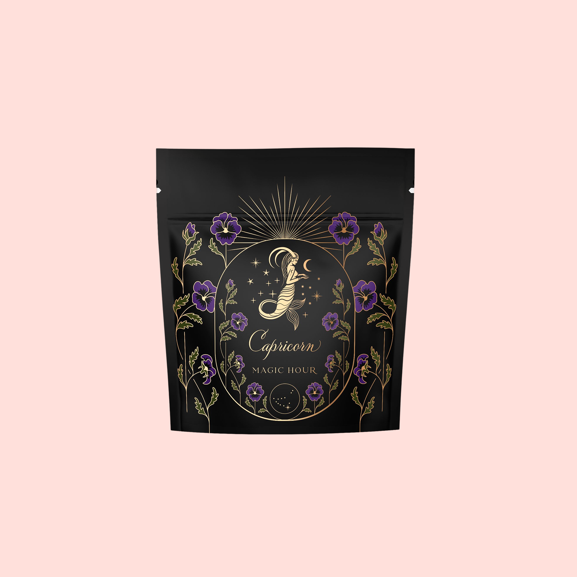 A black stand-up pouch with gold and purple floral design, labeled "Capricorn" and "Magic Hour," showcases Capricorn: Maple Oolong Tea for its metabolism-boosting benefits, set against a pale pink background.