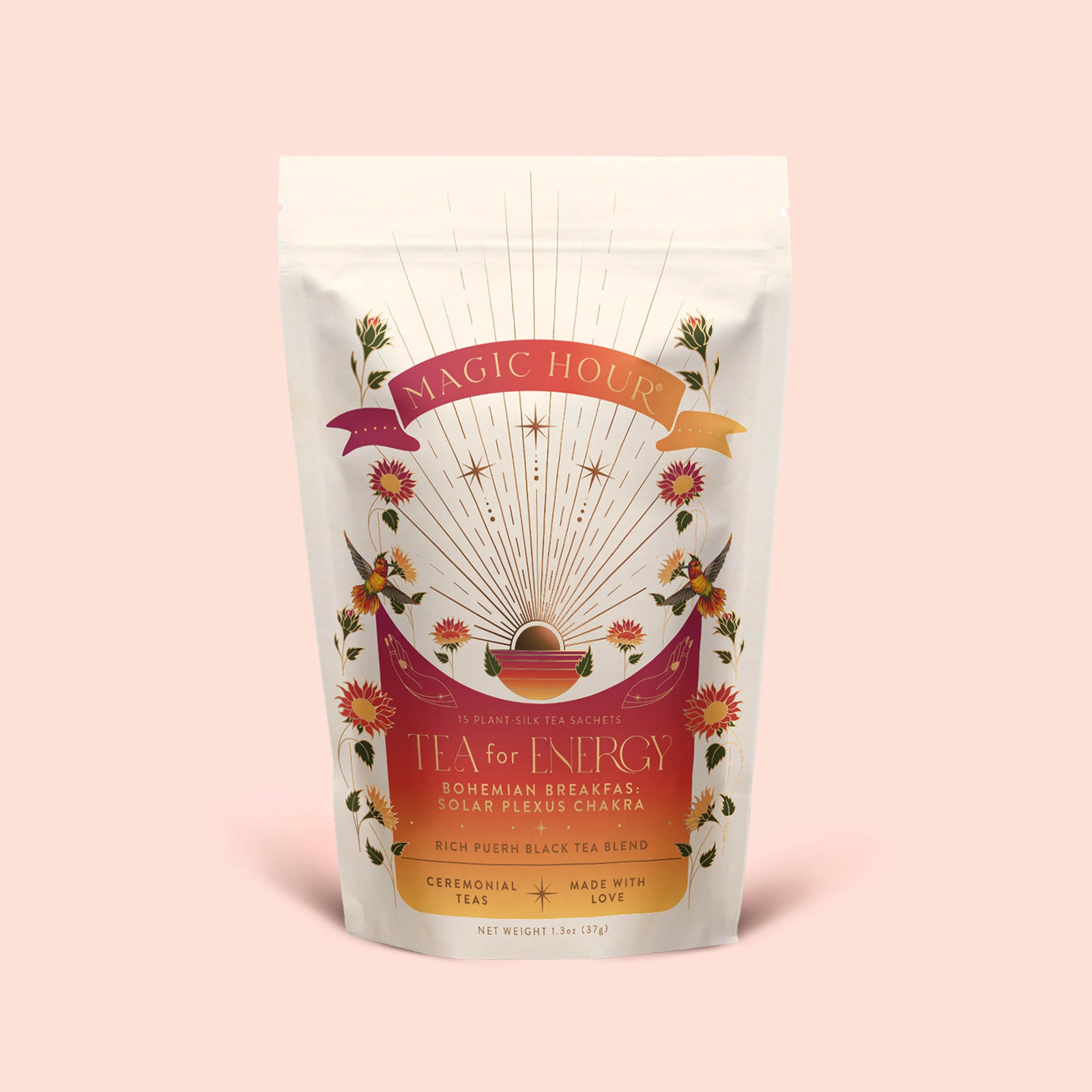 A white tea pouch labeled "Tea for Energy: Bohemian Breakfast: Rich Puerh Black Tea Blend" features floral designs, rays, and a sun. The text highlights its support for energy and digestion with a probiotic-rich black tea blend inspired by the Solar Plexus Chakra—a ceremonial tea made with love.