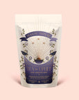 A pastel bag of Tea to Uplift: Earl Greater Grey features celestial and floral designs and is labeled "Tea to Uplift." The text describes the blend as black and white tea with bright notes of bergamot.