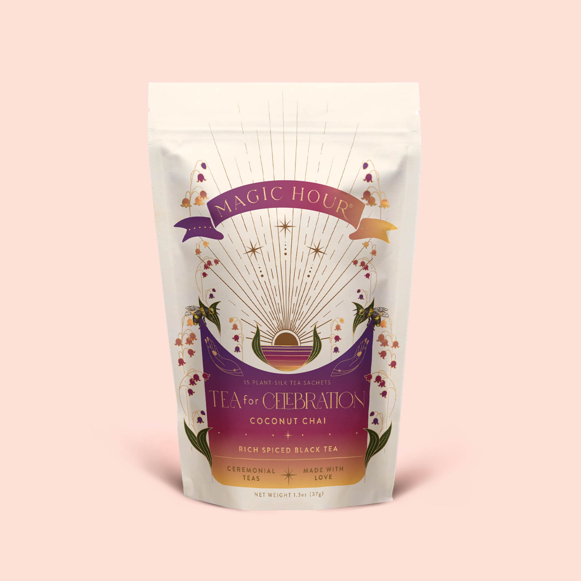 A pouch of Tea for Celebration: Coconut Chai: Rich Spiced Black Tea Blend, adorned with celestial and floral artwork featuring rays, stars, and hands holding a teacup on a light pink background. Infused with blue lotus, this blend is crafted to elevate your senses and awaken the crown chakra.