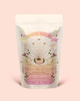 A pastel pouch of Tea for Abundance: Goddess Green: Apricot & Lychee Green Tea features floral designs, gold rays, and text describing it as a solar plexus chakra tea, blending apricot and lychee green tea with organic lemongrass for a biodynamic infusion.