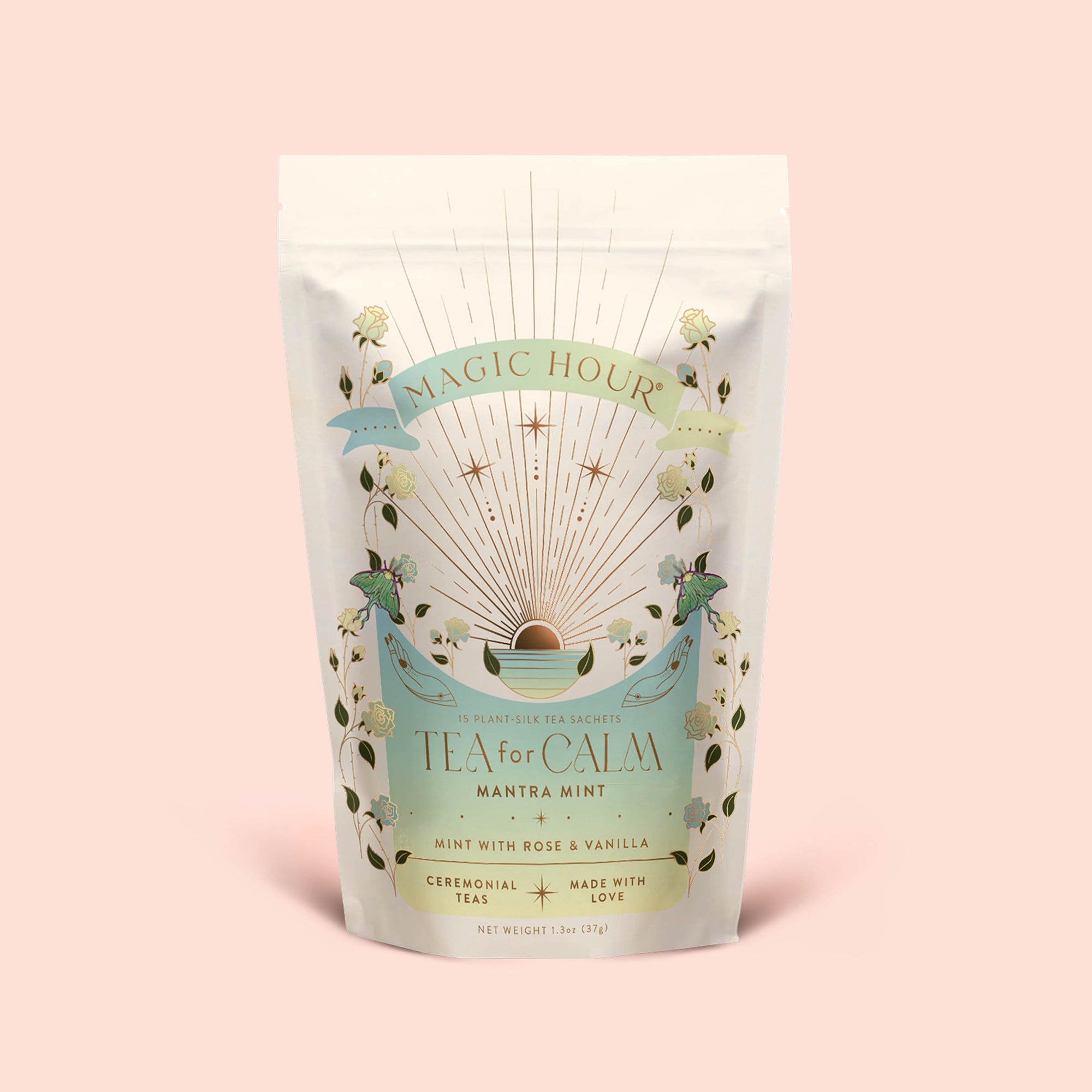 A pastel-hued pouch of Magic Hour's Tea for Calm: Mantra Mint: Mint With Rose &amp; Vanilla Herbal Tea features floral and celestial artwork, labeled "Mint with Rose &amp; Vanilla" and "Ceremonial Teas Made with Love." This soothing organic blend combines calming botanicals to create a serene tea experience in every cup.