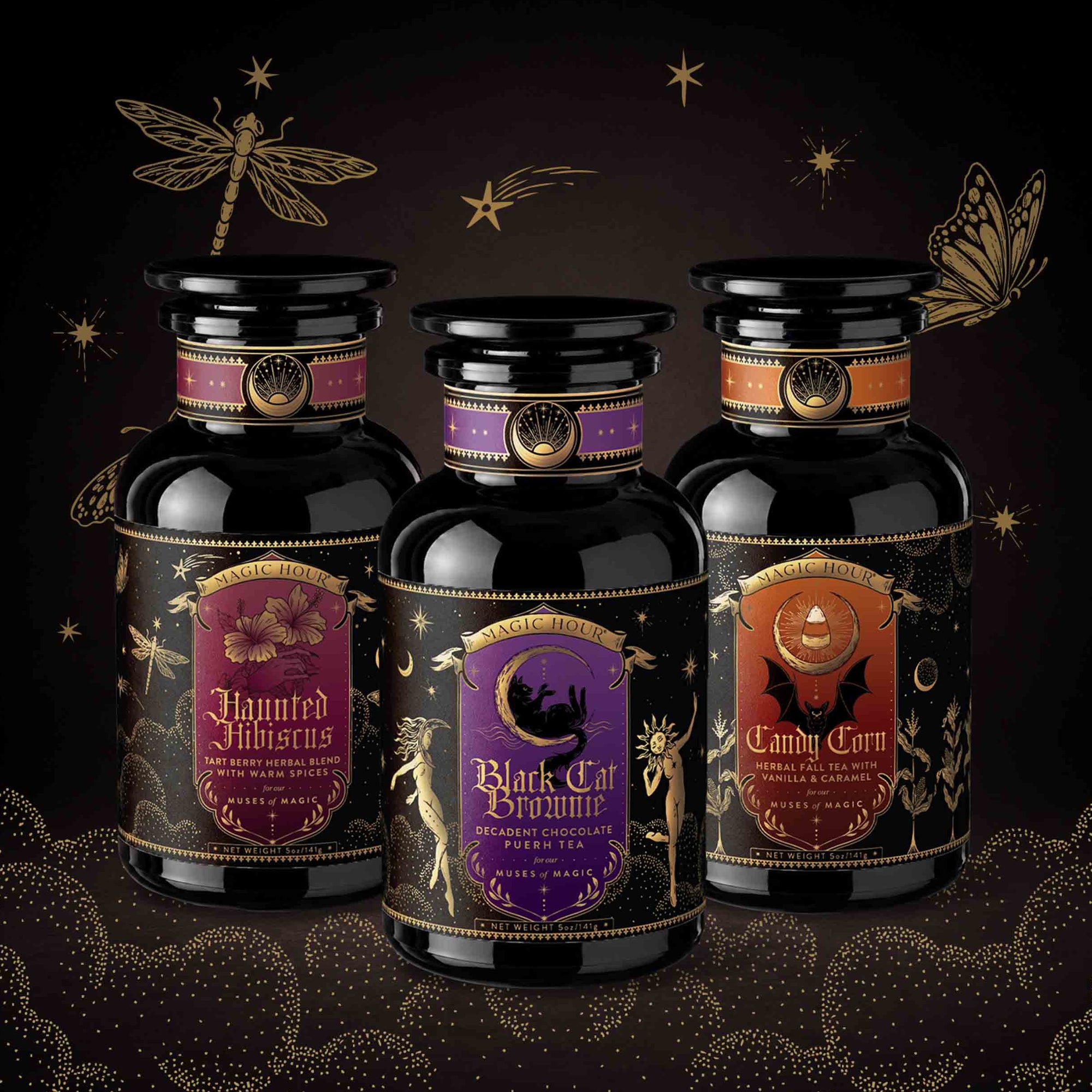 Three ornate black bottles with decorative labels—Haunted Hibiscus, Black Cat Brownie, and Candy Corn—stand against a dark, starry backdrop adorned with illustrated moths, dragonflies, and celestial motifs. This Halloween Bundle showcases limited edition hand-crafted tea blends from the Small Batch Magic Halloween Edition, perfect for celebrating the enchanting spirit of the season.