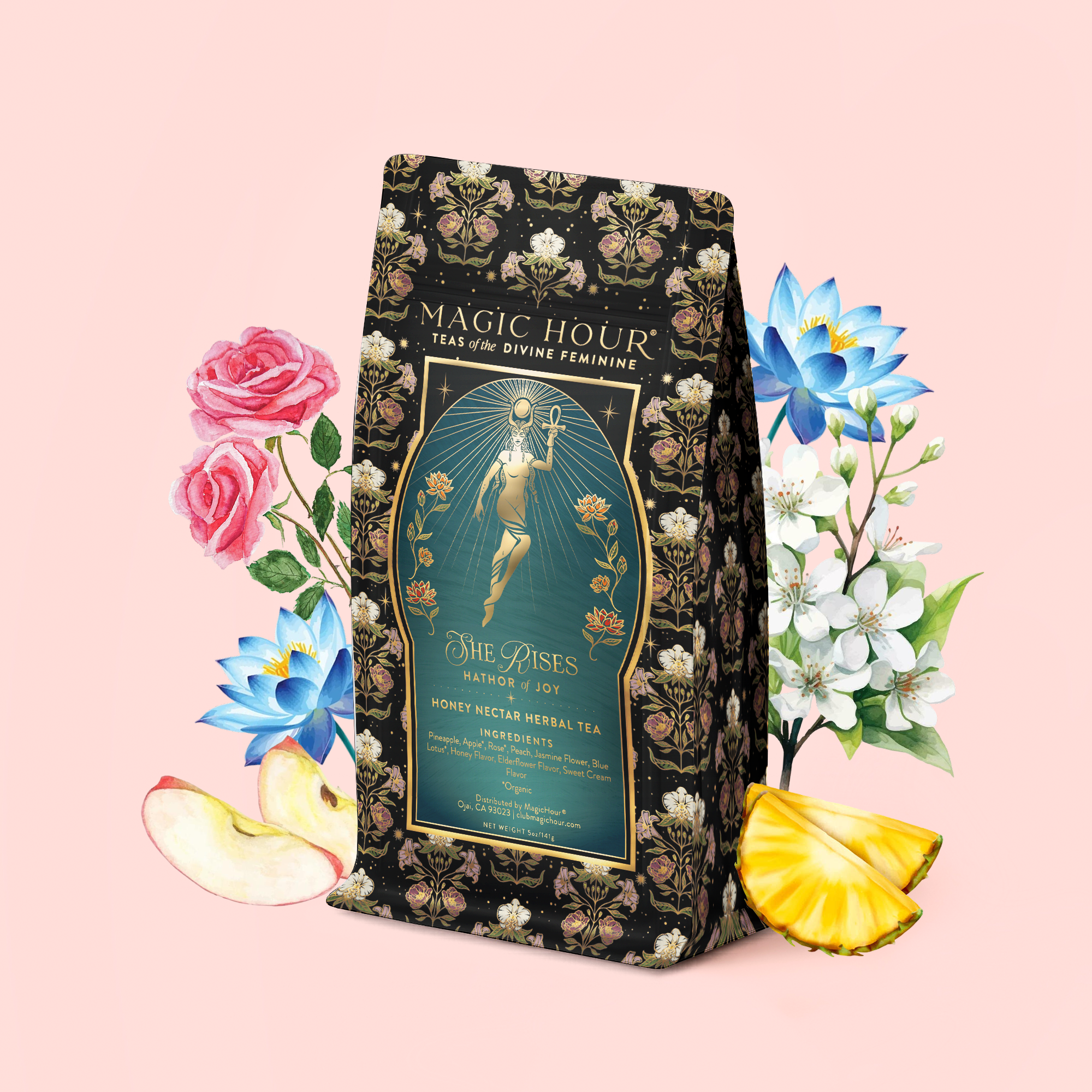 A floral-adorned tea package labeled "Magic Hour" sits amidst illustrated roses, apple slices, pineapple, and delicate white blossoms—evoking the enchanting flavors inside. Set against a pale pink background, the scene invites you to discover delights such as Hathor of Joy: Honey Nectar Herbal Tea nestled within.