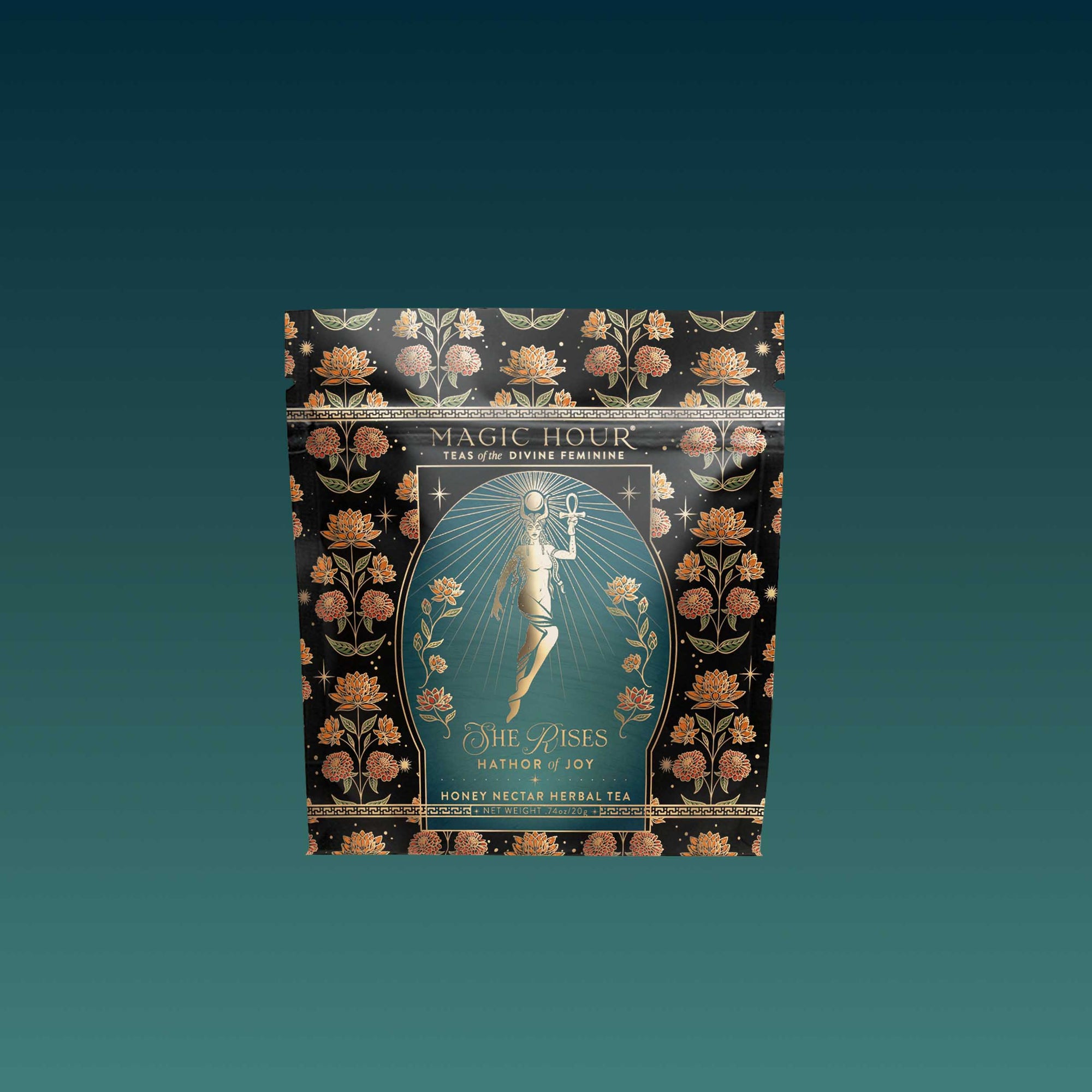 A decorative pouch of Magic Hour’s Monthly Magic Tea Journey Subscription, adorned with florals and a rising woman—ideal for goddess rituals. Labeled "Nectar of Joy Honey Nectar Herbal Tea" on a gradient teal background.