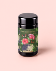 Discover Hibiscus Elderberry: Cosmic Garden Iced Tea, presented in a sleek black canister adorned with a vibrant label of hibiscus, lavender, and delicate white flowers. The light pink label highlights the name “Cosmic Garden Iced Teas - Hibiscus Elderberry.” Bursting with antioxidants, this organic hibiscus iced tea is expertly crafted to be both refreshing and nourishing—an ideal afternoon pick-me-up.