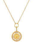 The Inward Journey Pearl Mandala Necklace showcases a circular mandala pendant featuring a sun design, embellished with alternating gold and pearl-like segments forming the sun's rays. This spiritual jewelry piece is suspended from a delicate 18KT gold plated chain, connected by a ring to the pendant.