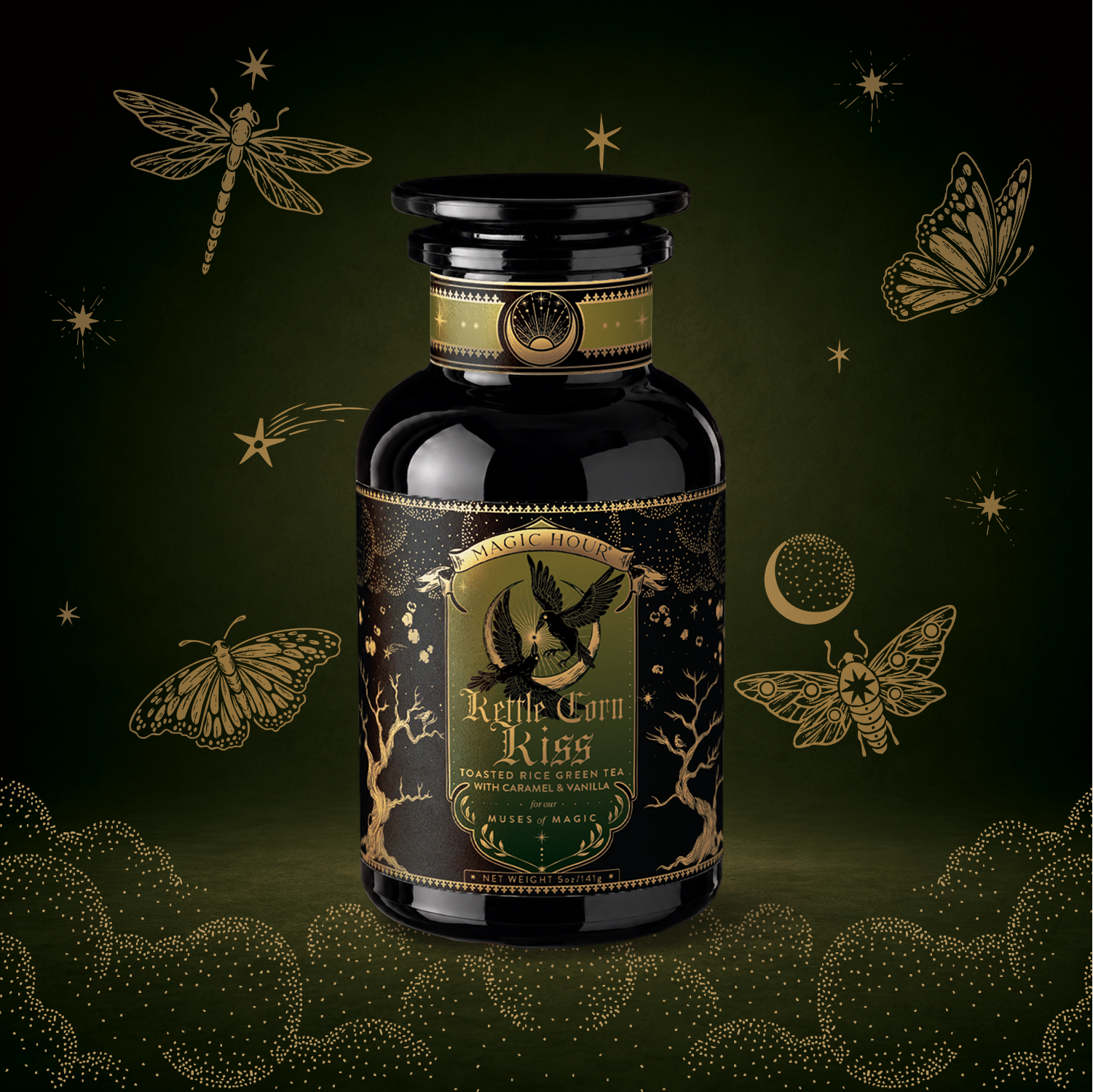 A dark glass bottle labeled “Kettle Corn Kiss: Sweet & Nutty Toasted Rice Green Tea with Caramel & Vanilla” sits on a green background adorned with gold dragonflies, moths, a crescent moon, stars, and foliage—evoking a whimsical, magical feel that perfectly captures the enchanting flavors of caramel and vanilla blended with the sweet nuttiness of toasted rice green tea inside.