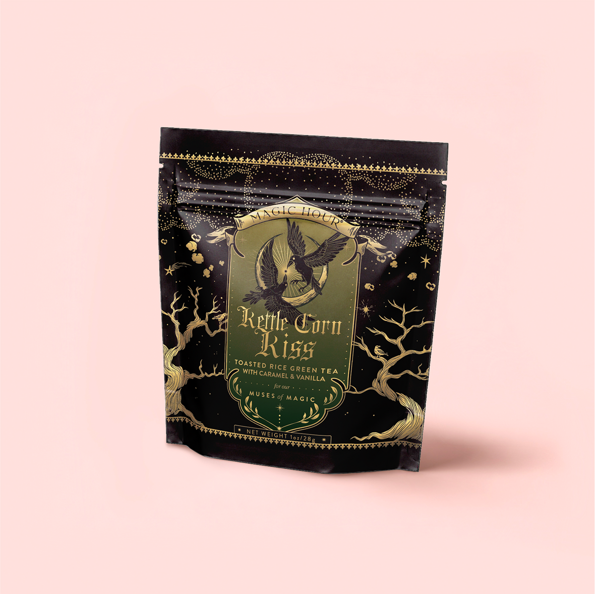 A black and gold pouch of Kettle Corn Kiss: Sweet & Nutty Toasted Rice Green Tea with Caramel & Vanilla, decorated with an owl, stars, and trees, sits upright against a light pink background.