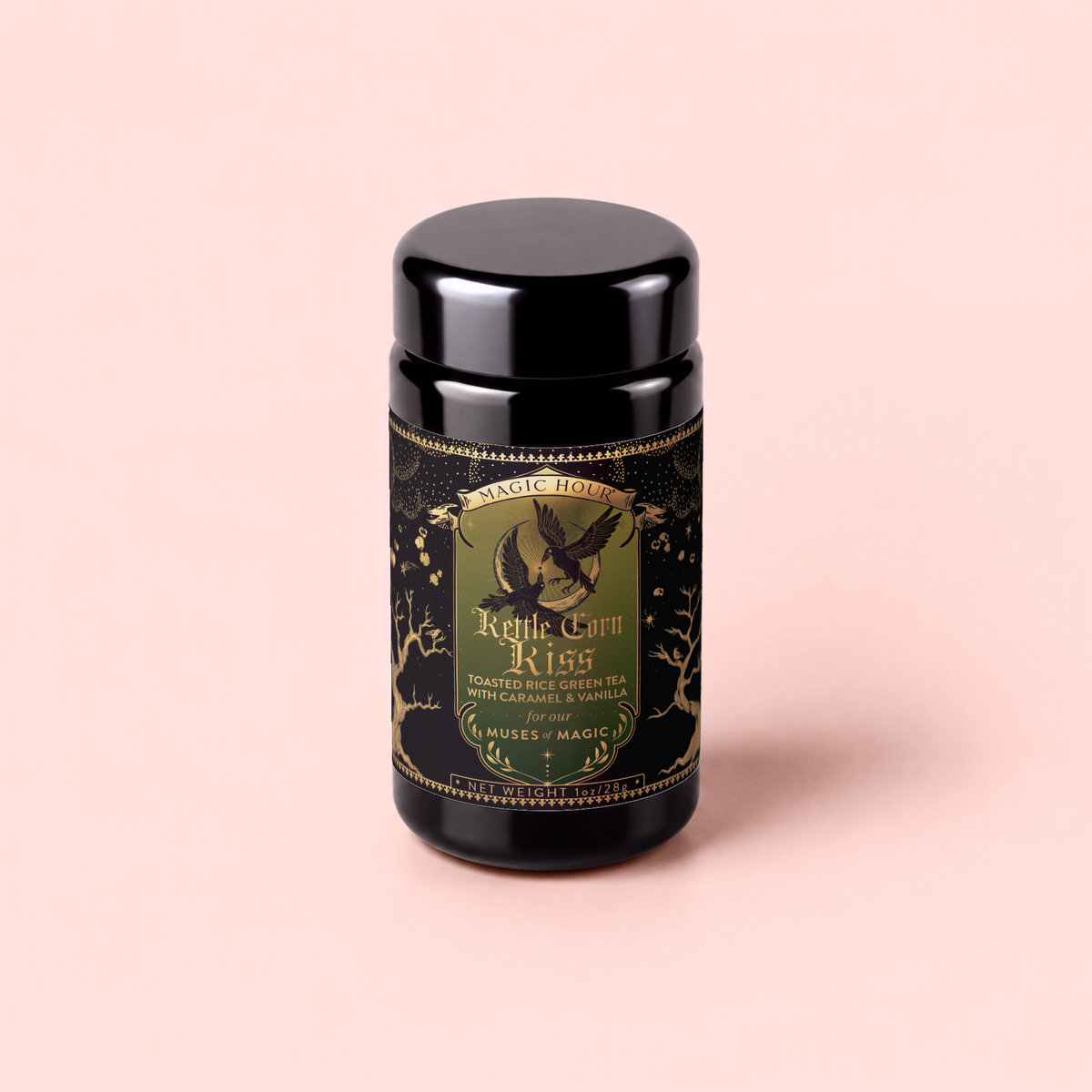 A black canister labeled “Kettle Corn Kiss: Sweet &amp; Nutty Toasted Rice Green Tea with Caramel &amp; Vanilla” features gold accents, an owl illustration, and ornate designs, set against a pale pink background.