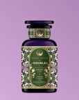 A decorative purple bottle labeled "111: Lavender-Jasmine-Pineapple Herbal Tea with Blue Lotus" features ornate floral designs, gold accents, and butterfly pea flower hints against a light purple gradient, referencing the Crown Chakra.