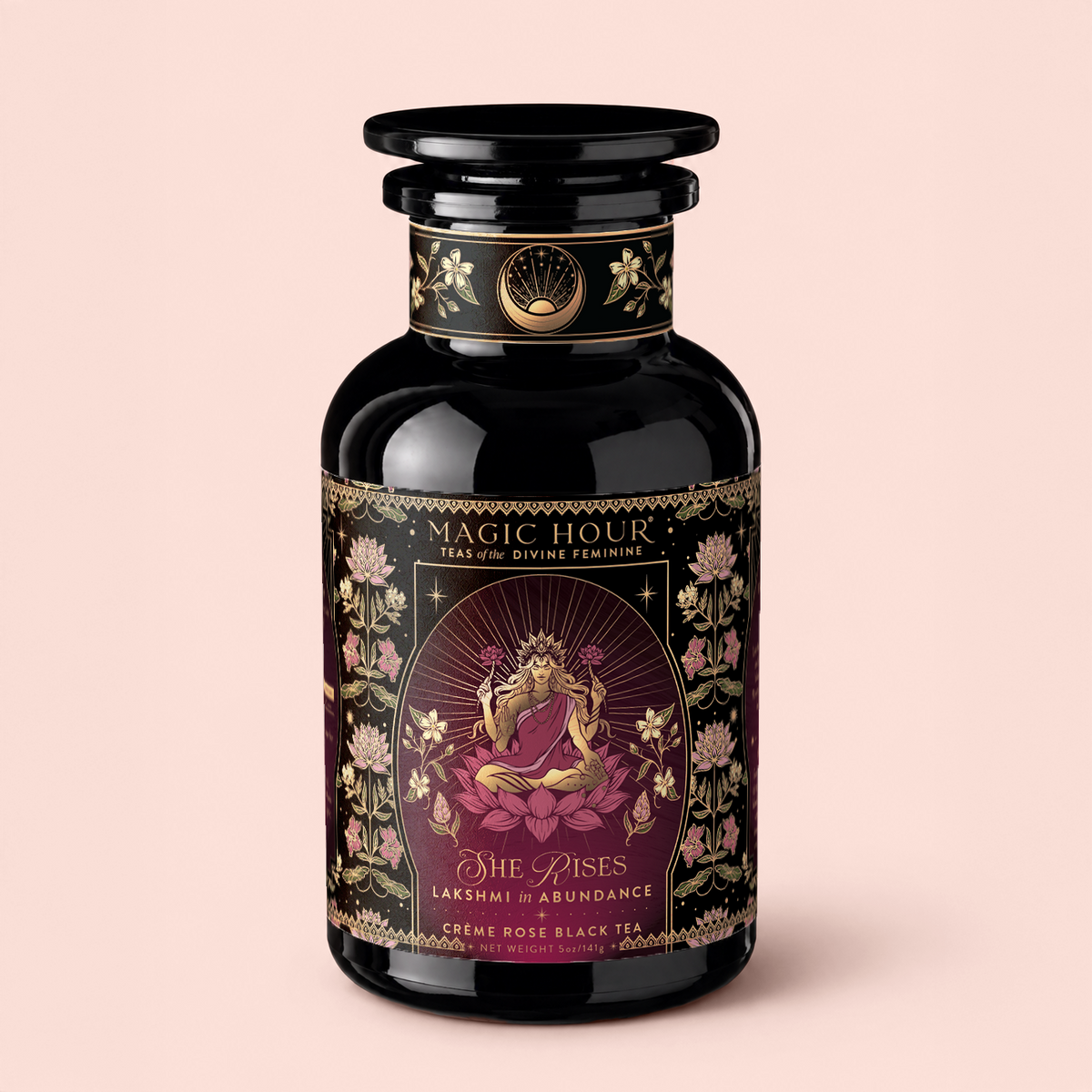A black jar labeled “Magic Hour Teas of the Divine Feminine” features floral designs and an illustration of Lakshmi. This luxury black tea is called “Lakshmi in Abundance: Rose Saffron Black Tea for Good Fortune &amp; Radiance,” offering an antioxidant-rich tea experience inspired by abundance and grace.