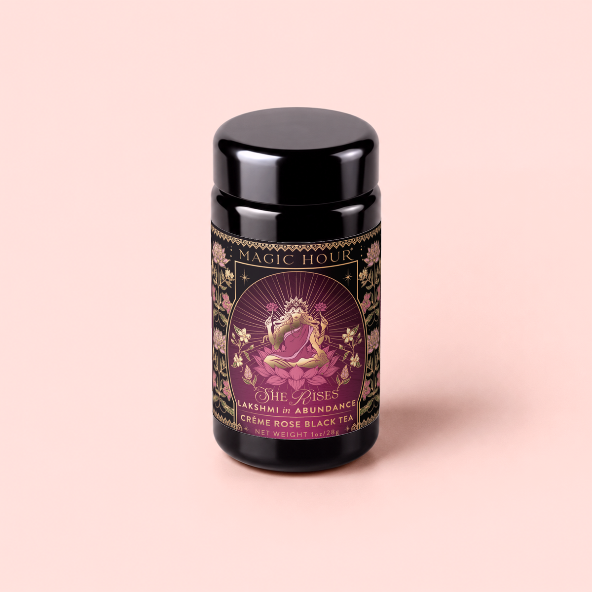 A black tea canister labeled “Lakshmi in Abundance: Rose Saffron Black Tea for Good Fortune &amp; Radiance,” adorned with ornate floral designs and an illustration of a woman in a pink sari, perfectly capturing the essence of this antioxidant-rich tea.