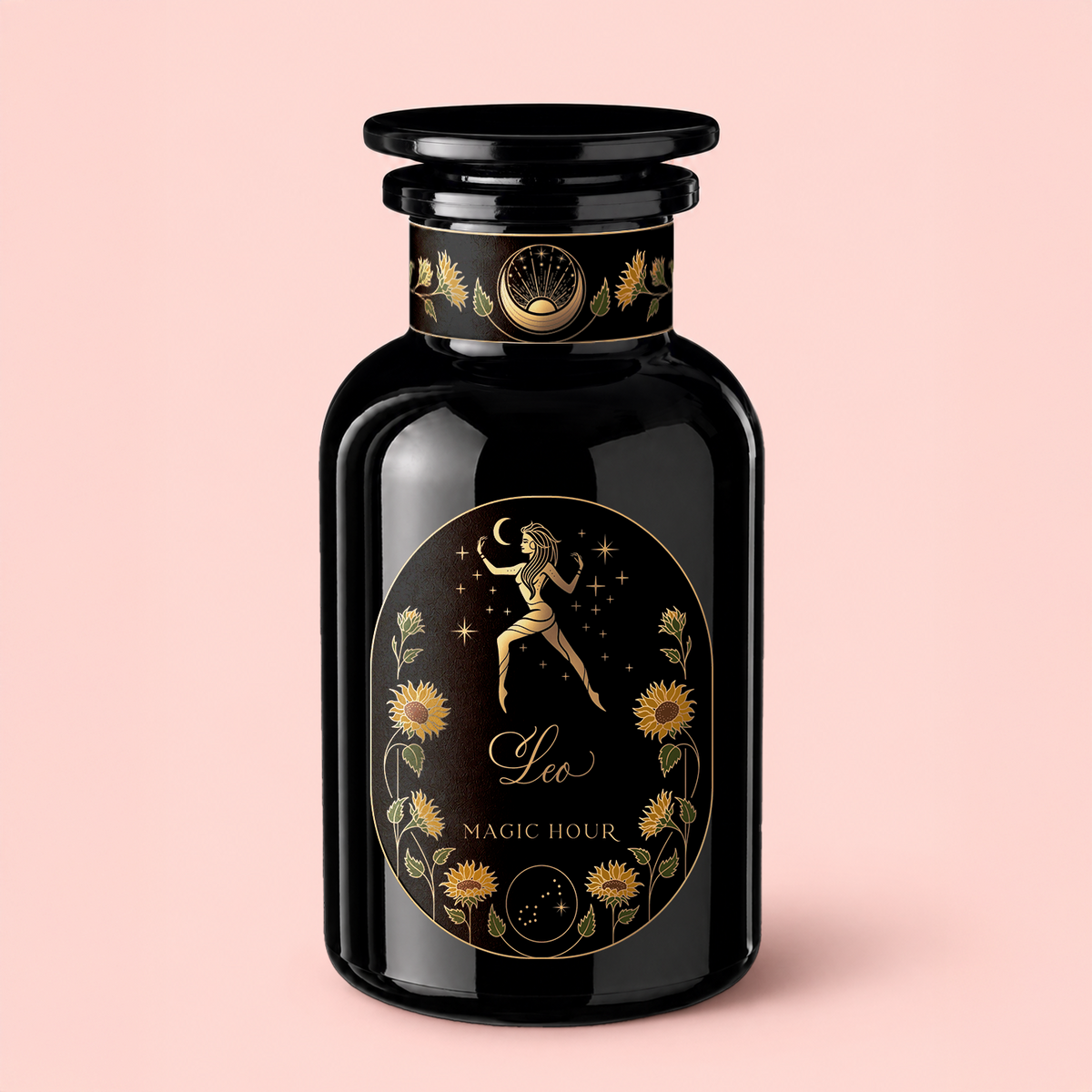 A black glass bottle features a decorative label with a golden figure holding a crescent moon, surrounded by flowers and stars. The label displays “Leo: Queen of Courage Tea of the Sun” and “Magic Hour” on a pale pink background—hinting at mystical blends within, such as Yunnan Black Tea Pearls or the invigorating touch of Lion’s Mane.