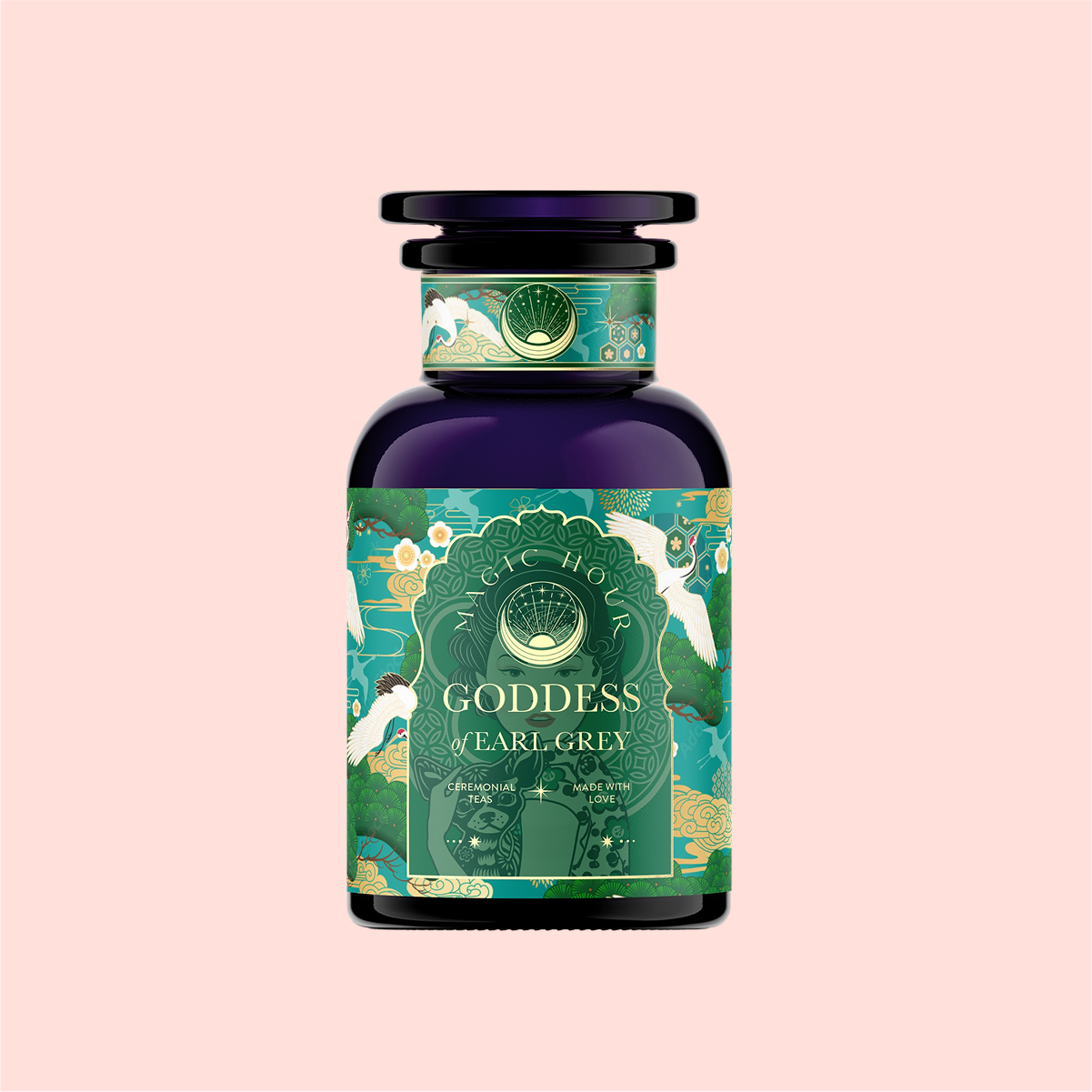 A dark purple bottle labeled "London Fog Green" from Magic Hour features ornate patterns with peacocks, showcasing a green, gold, and blue color scheme against a light pink background. The hint of lavender beautifully complements the bergamot notes.