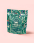 A green, floral-patterned stand-up pouch labeled "London Fog Oolong" with peacock and leaf designs sits against a light pink background. The packaging highlights notes of bergamot and vanilla, Magic Hour, and Quan Yin oolong.