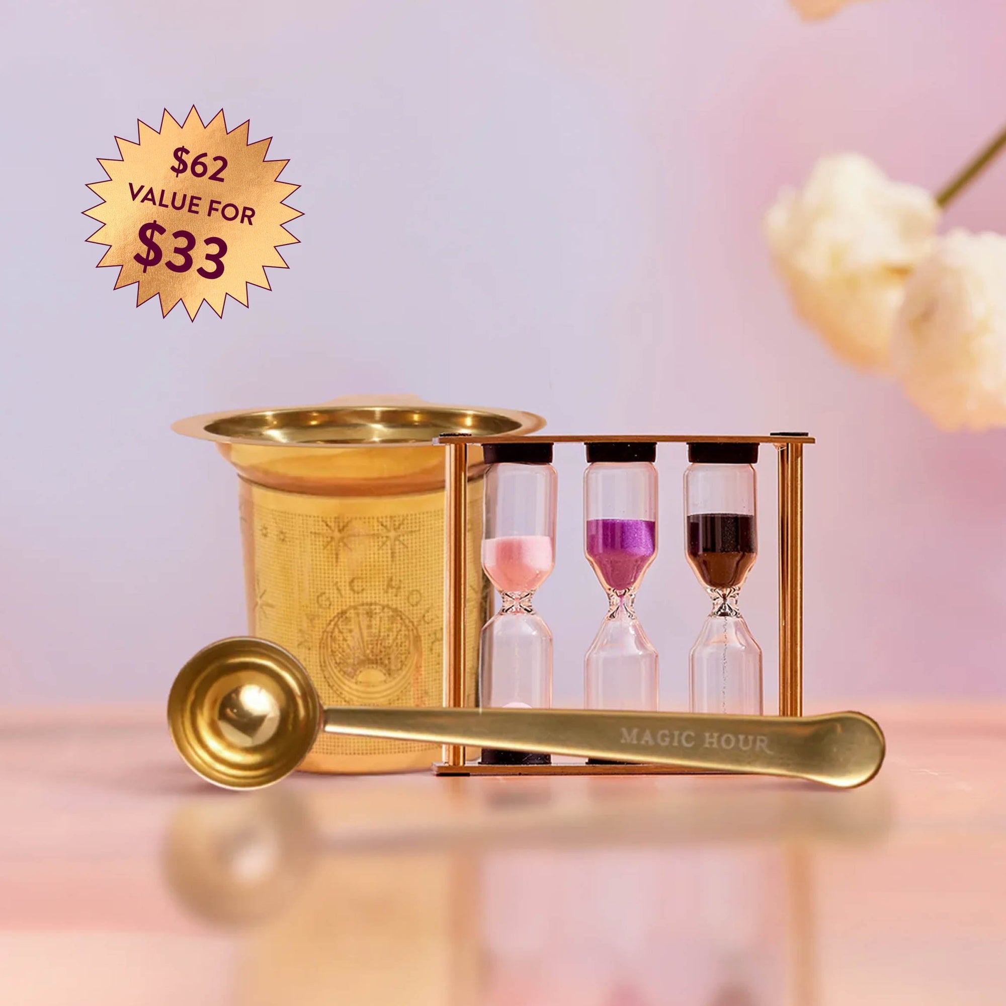 The Loose Leaf Tea Starter Set includes a gold strainer, "Magic Hour" gold tea scoop, and a three-chamber tea timer with pink, purple, and black sand. A label shows "$62 value for $33." Cream flowers decorate the background.