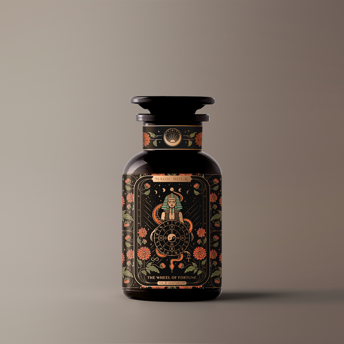 A dark glass bottle with a vintage apothecary design. The label showcases intricate floral and celestial illustrations along with the text "Magic Hour" and "The Wheel of Fortune." The product, named "The Wheel of Fortune," is set against a simple, gradient background.