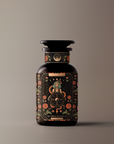 A dark glass bottle with a vintage apothecary design. The label showcases intricate floral and celestial illustrations along with the text "Magic Hour" and "The Wheel of Fortune." The product, named "The Wheel of Fortune," is set against a simple, gradient background.