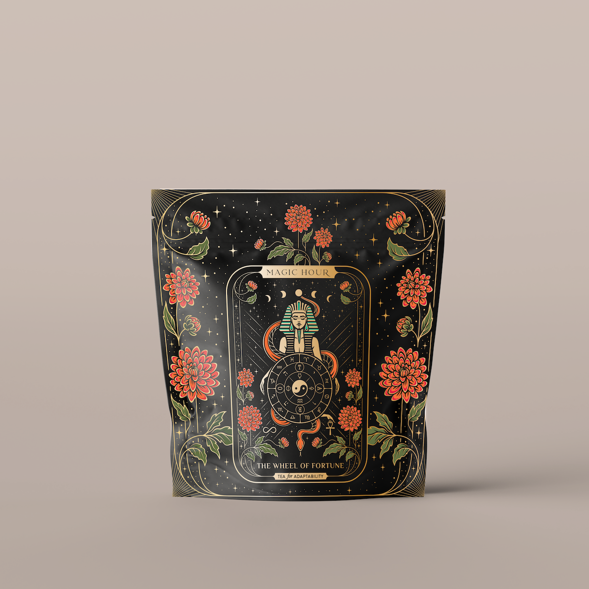 A black, resealable bag adorned with ornate, mystical gold and red designs. The center features a wheel with intricate symbols, flanked by two snakes and surrounded by vibrant red flowers and delicate gold leaves. Text at the top reads &quot;The Wheel of Fortune&quot;.