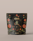 A black, resealable bag adorned with ornate, mystical gold and red designs. The center features a wheel with intricate symbols, flanked by two snakes and surrounded by vibrant red flowers and delicate gold leaves. Text at the top reads "The Wheel of Fortune".