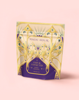 A standing pouch of Maple Oolong: Cozy & Connected, an autumn tea blend featuring ornate art deco-style gold and purple designs on a light pink background.