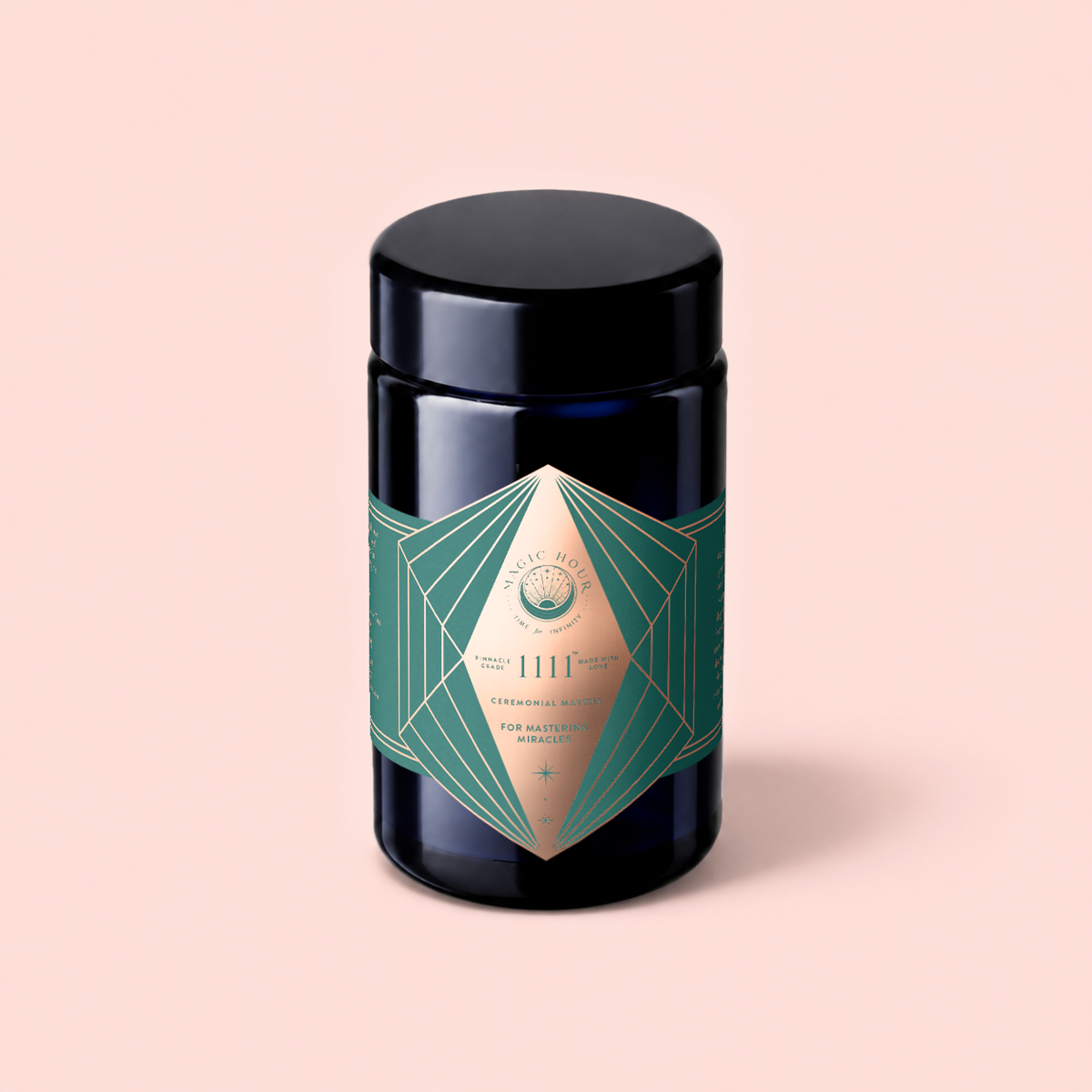 A dark glass jar with a green and gold geometric label reading “1111” and “ceremonial wellness” stands against a pale pink background, reflecting the premium tradition of Matcha 1111 : Highest Grade of Ceremonial Matcha.