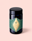 A dark jar featuring a gold and green geometric label with “Organic Ceremonial Matcha 700” sits on a light pink background, emphasizing the premium quality of this organic ceremonial matcha sourced from Kagoshima.