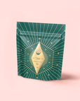 A green resealable pouch with gold starburst and line designs displays a diamond label reading "700" and "Green" on pale pink—ideal for presenting Organic Ceremonial Matcha 700 from Kagoshima.