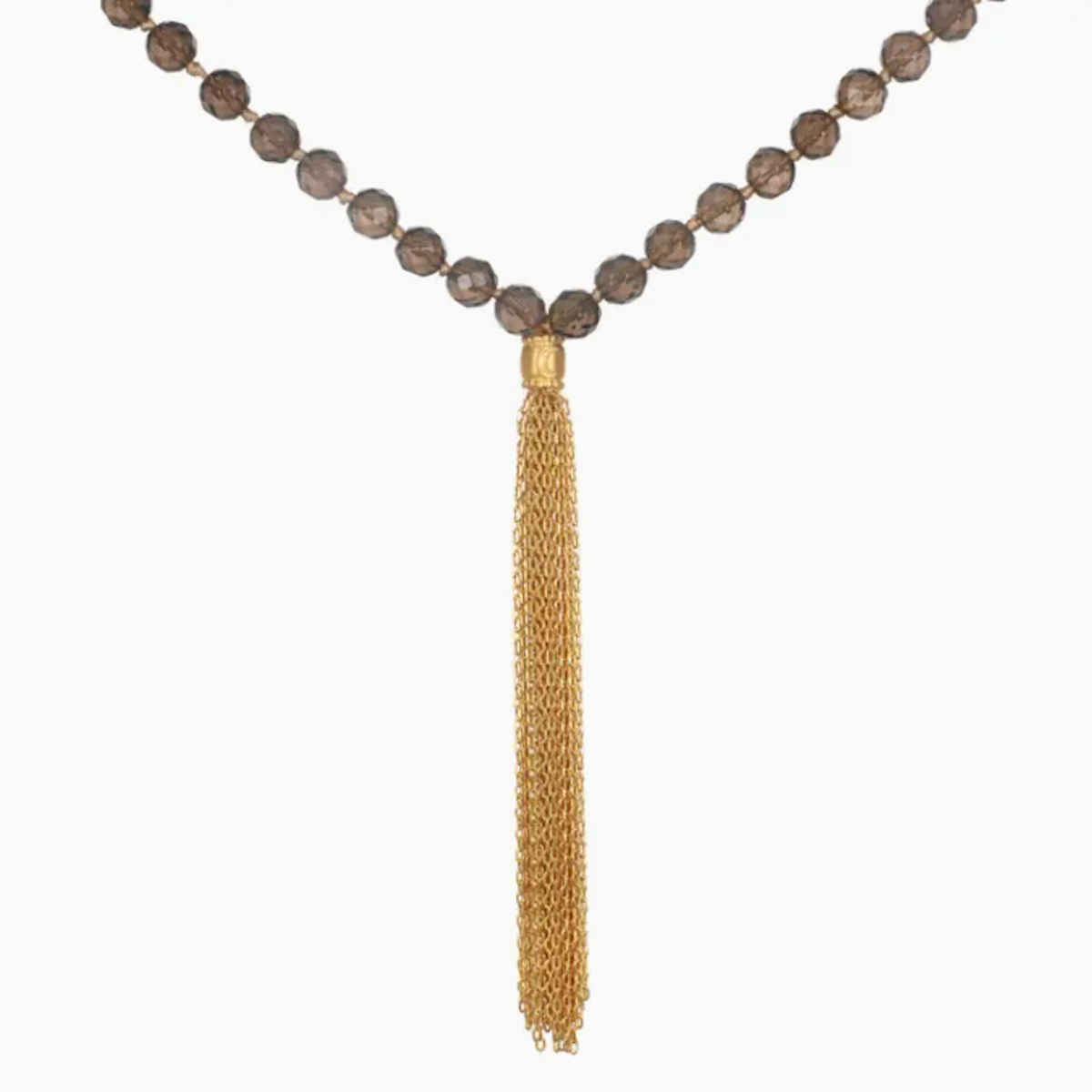 A **Moon Smokey Quartz Mala** composed of dark brown spherical beads reminiscent of an ancient prayer necklace, featuring a long, gold chain tassel pendant hanging in the center. The brown beads form a V-shape while the gold tassel pendant adds a contrasting, elegant touch. This exquisite necklace is crafted by **Magic Hour**.