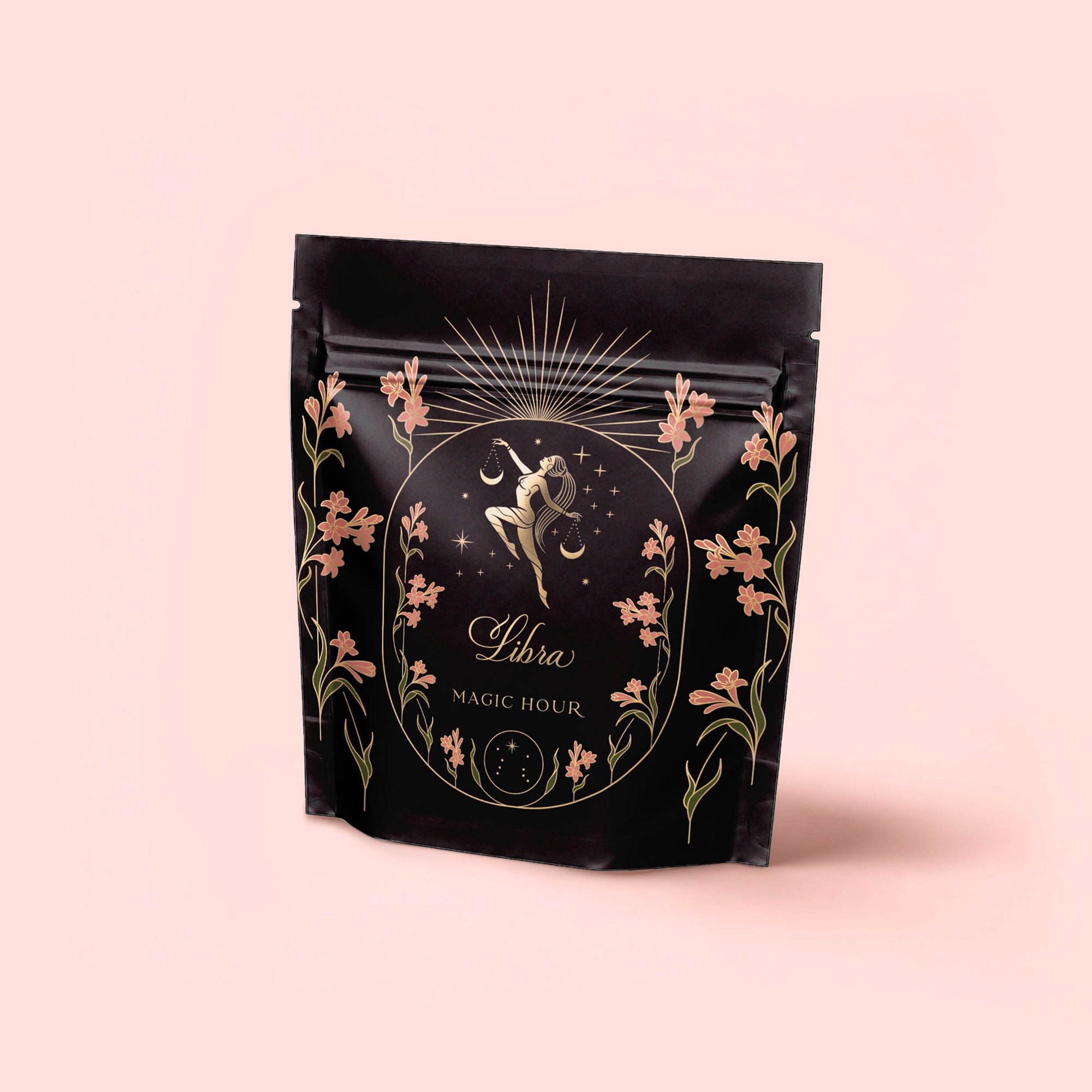A black resealable pouch labeled “Libra Shatavari-Cardamom-Rose White Love Cake Tea” features gold and pink florals, a Libra zodiac illustration, and celestial details that evoke the tea’s delicate Persian love cake-inspired flavors.