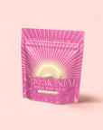 A pink resealable pouch labeled "Cream Soda White Tea: Ceremonial Soda Tea" with golden rays and bubbles stands upright against a light pink background—this blend is a delightful cream soda-inspired white tea.