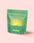 A green and yellow stand-up pouch labeled "Lemon Lime Green Tea: Ceremonial Soda Pop Tea" with a sunburst design, featuring lemon tea and Gymnema Sylvestre, is set against a plain light pink background.