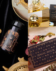 A luxurious display of Magic Hour tea products includes the Black Onyx December Birthstone Mini Gift Set, featuring a black tea container adorned with gold geometric designs. The set is complemented by a beautifully labeled "Magic Hour" tea box and a gold tea infuser, all elegantly arranged on mirrored surfaces that exude grounding energy against decorative backgrounds.