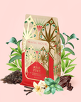 A festive package of Peppermint Bark Puerh, celebrated for supporting metabolism and digestion, surrounded by tea leaves, chocolate, vanilla, and bark, set against a light pink background.