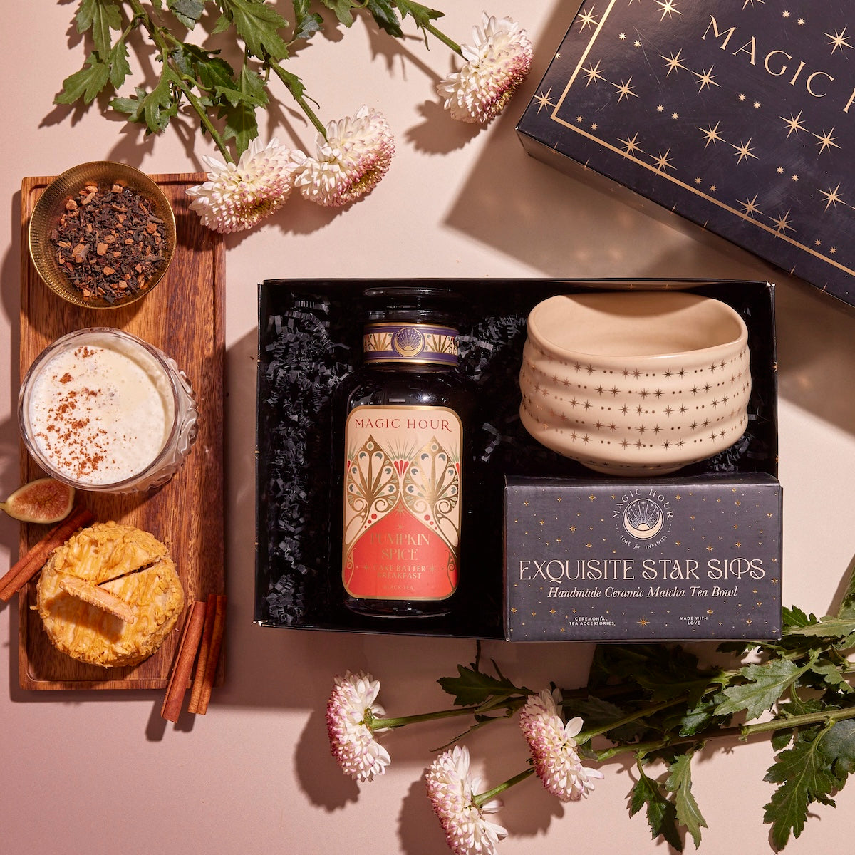 The "Pumpkin Lovers Tea & Accessory Gift Set" offers a captivating presentation with a tea jar, an elegant box of "Exquisite Star Sips" mugs, and a ceremonial tea bowl. Delight in the cozy warmth of pumpkin spice tea complemented by cinnamon sticks, dried orange slices, and floral accents.