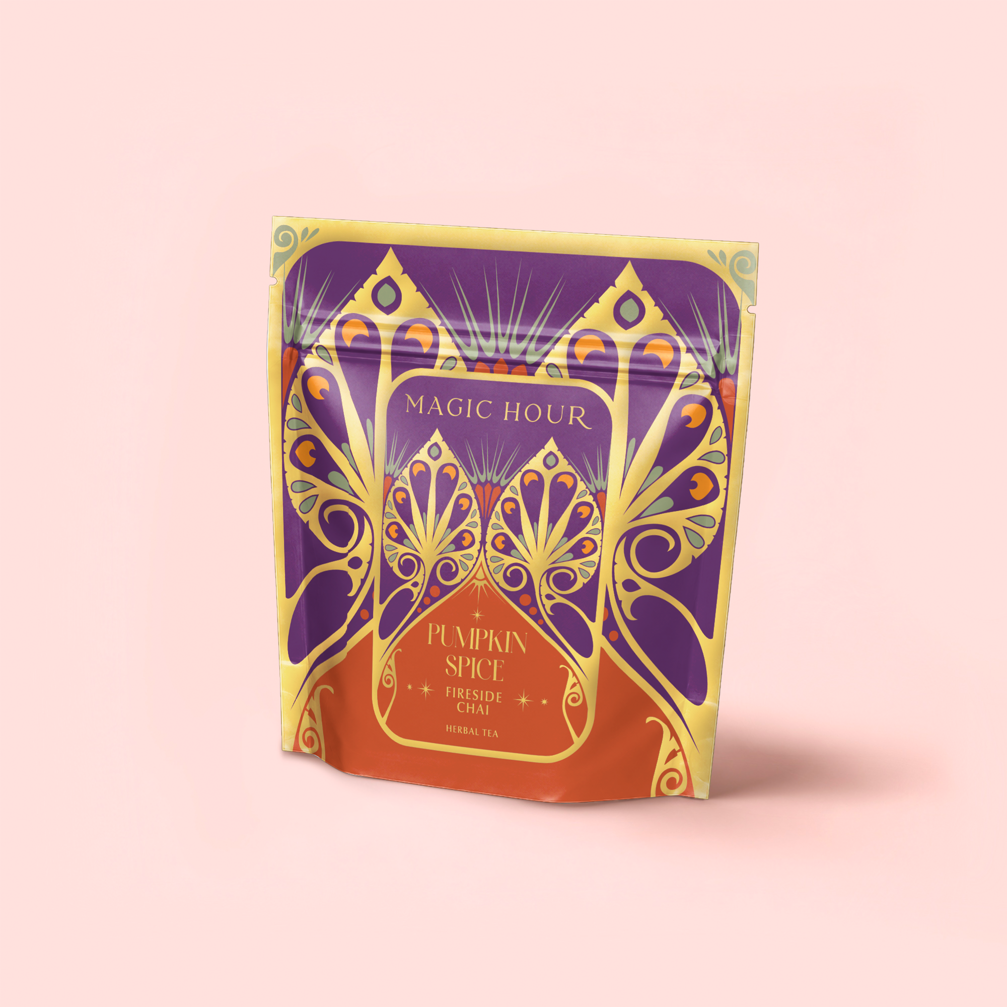 A colorful pouch labeled "MAGIC HOUR" with ornate orange, gold, and purple designs features "Pumpkin Spice Fireside Chai"—an antioxidant-rich, caffeine-free herbal tea—set against a light pink background.