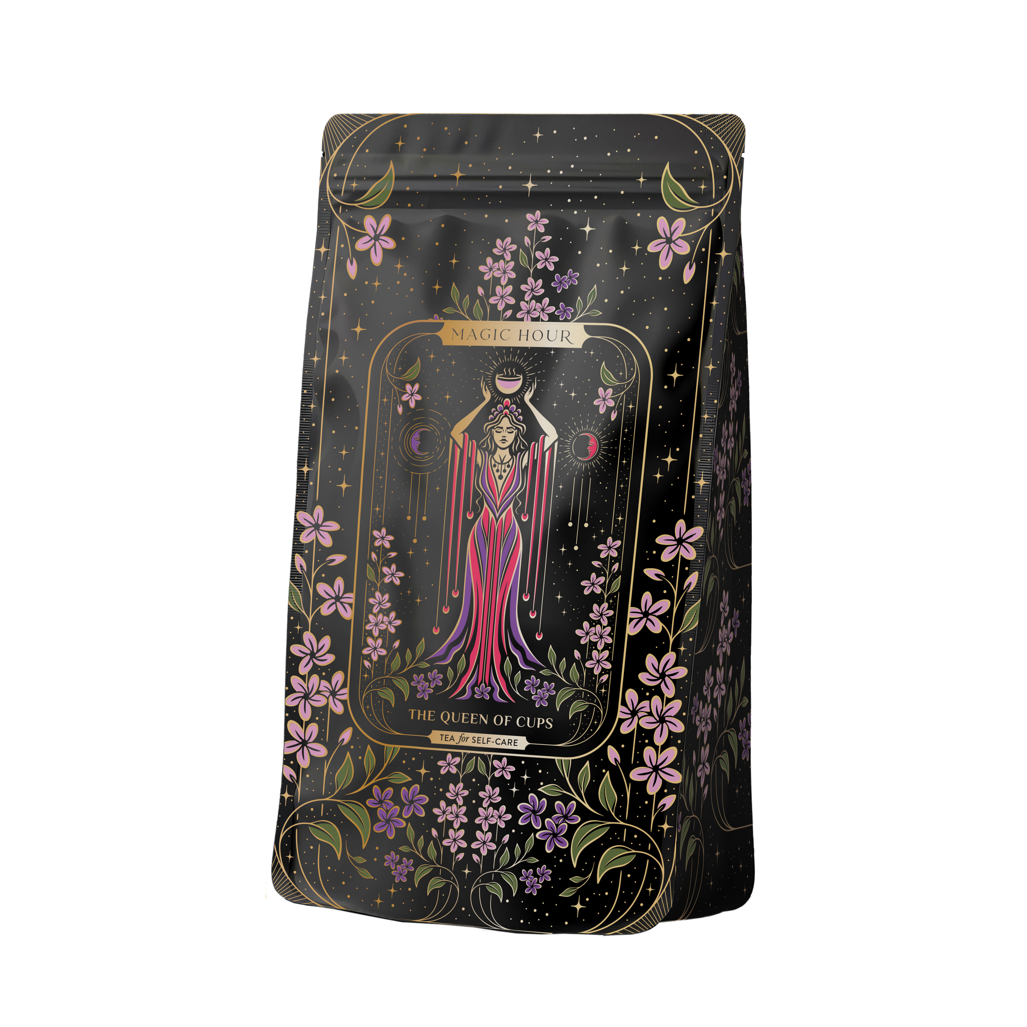 The Monthly Magic First Sips Tea Subscription Box includes a decorative tea package adorned with an illustration of a woman in a pink dress with flowing robes, holding two cups, reminiscent of Tarot archetypes. Surrounded by stars and purple flowers, the label reads “Magic Hour, The Queen of Cups,” providing an enchanting wellness tea experience.