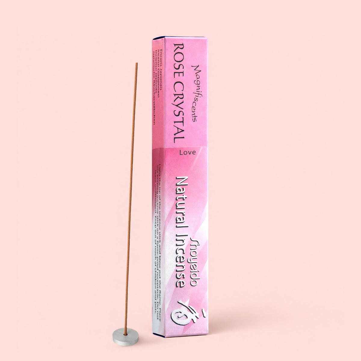 A box of Natural Incense : Rose Crystal, labeled “Love,” stands upright on a pink background beside a lit sandalwood incense stick in a small round holder.