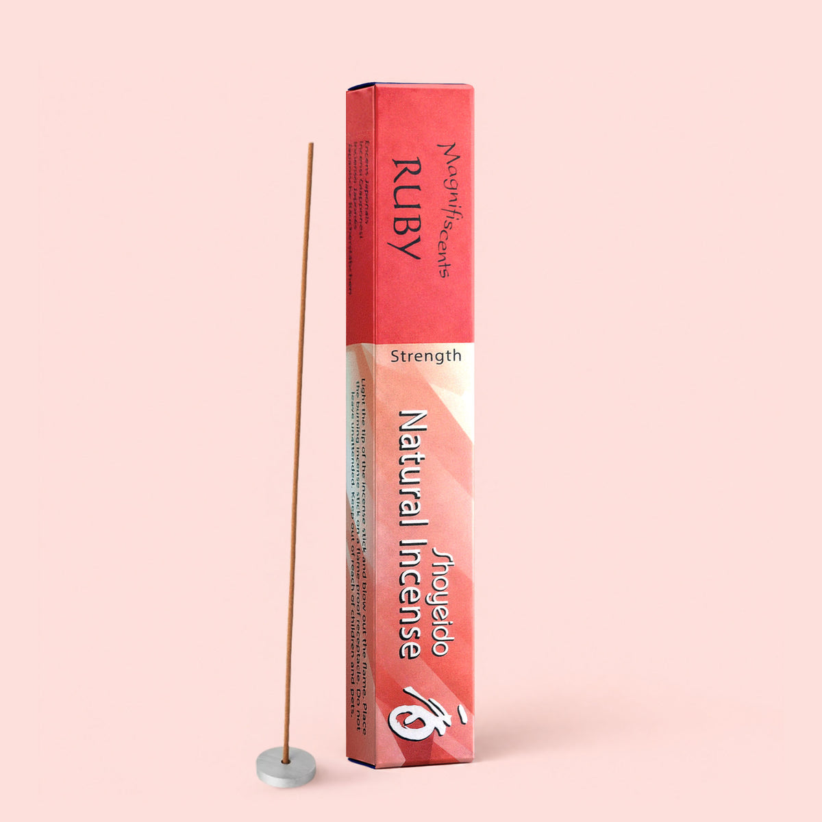 A box of Shoyeido Natural Incense : Ruby, renowned for its rich sandalwood aroma, stands upright beside a lit incense stick in a small round holder, set against a pale pink background.