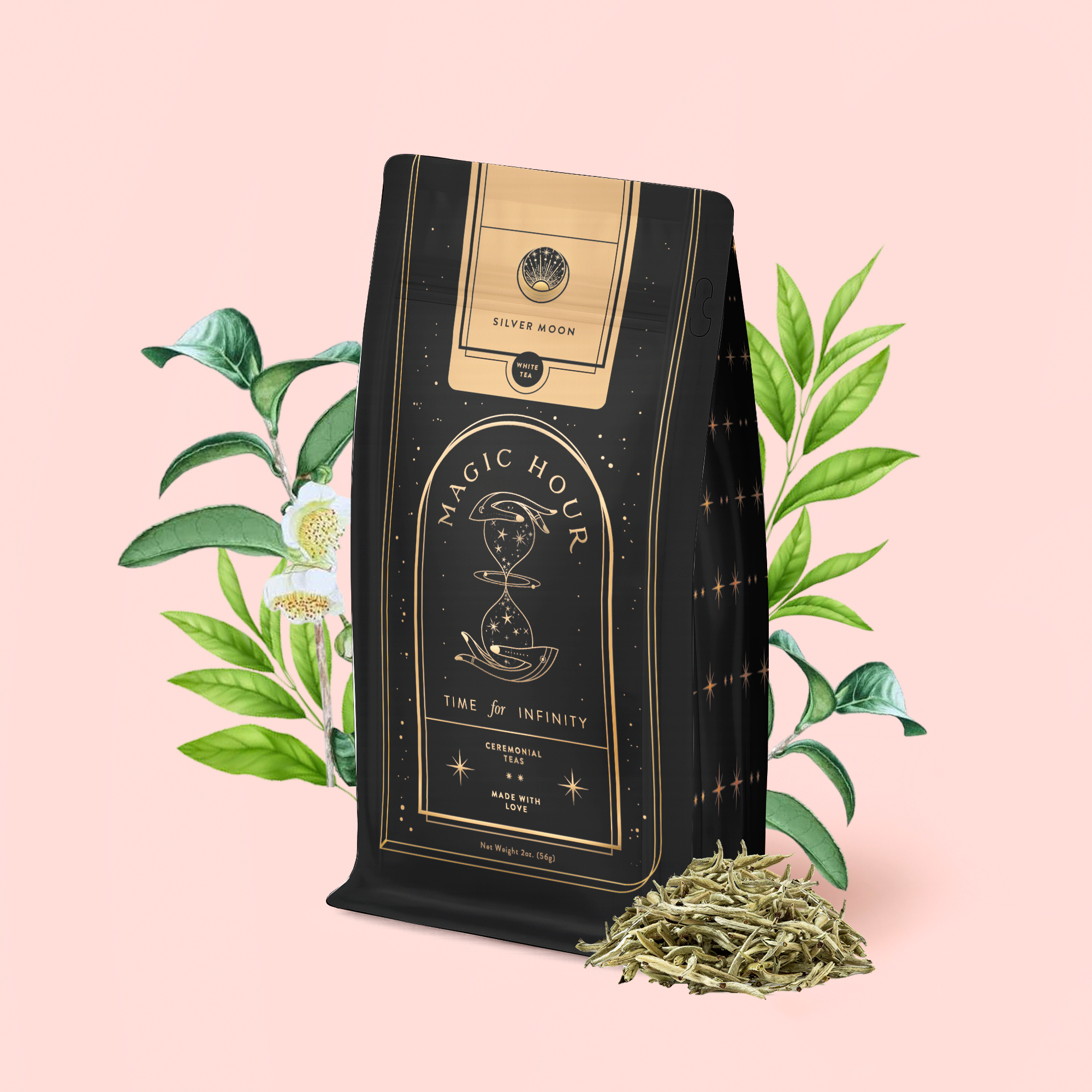A black and gold Magic Hour tea bag labeled "Silver Moon White Tea: Yin Zhen Silver Needle" stands on a pink background, with loose Fujian white tea leaves and illustrated green tea plants and flowers beside it.