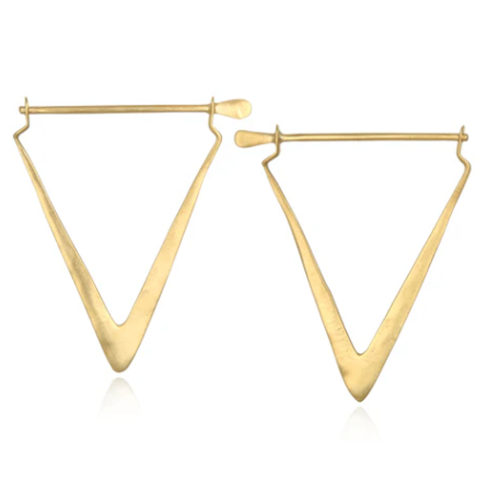 A pair of Simple Strength Earrings by Magic Hour in a geometric triangular shape. The metal is polished and features a smooth finish. The design highlights a modern silhouette, with each earring having a thin bar at the top for fastening. Made from 18k gold, these earrings are both minimalist and elegant.