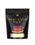 A product package featuring a black background adorned with gold stars displays the text "Lemon Lime Green Tea: Ceremonial Soda Pop Tea with Sugar 'Destroyer'," accompanied by an illustration of a pink teacup on a saucer below. Crafted using organic ingredients, the packaging from Magic Hour exudes a luxurious and enchanting design.